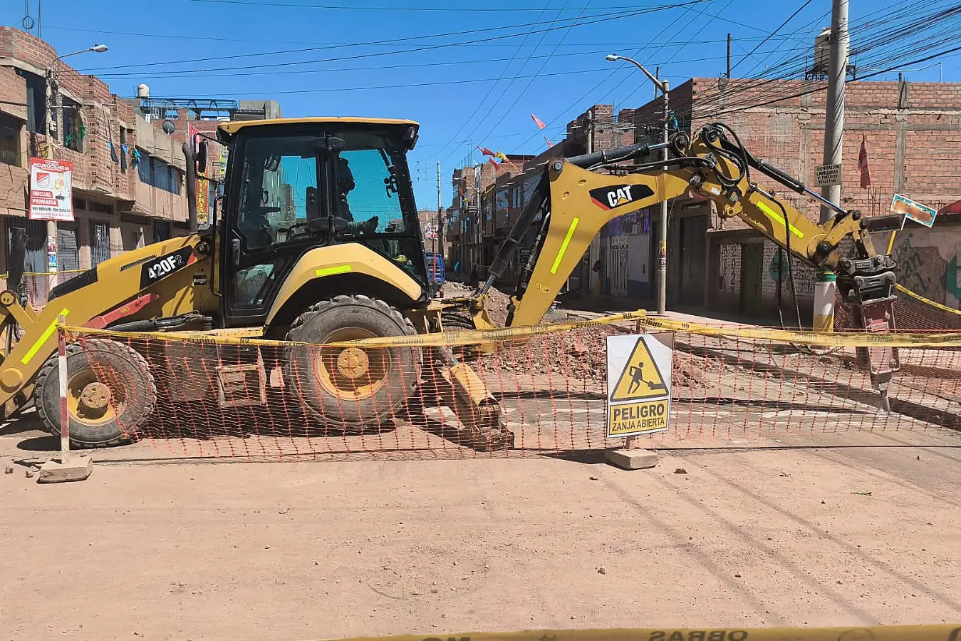 Retroexcavadora CAT 420F de DUNIMAR trabajando con operador en una zanja de saneamiento
